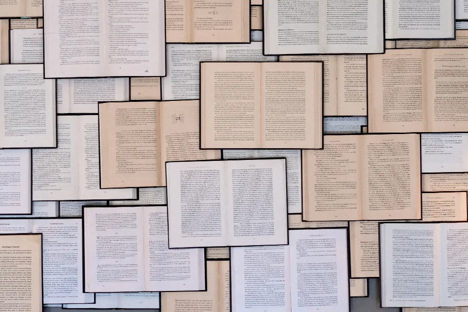 Many open books laid out in overlapping rows